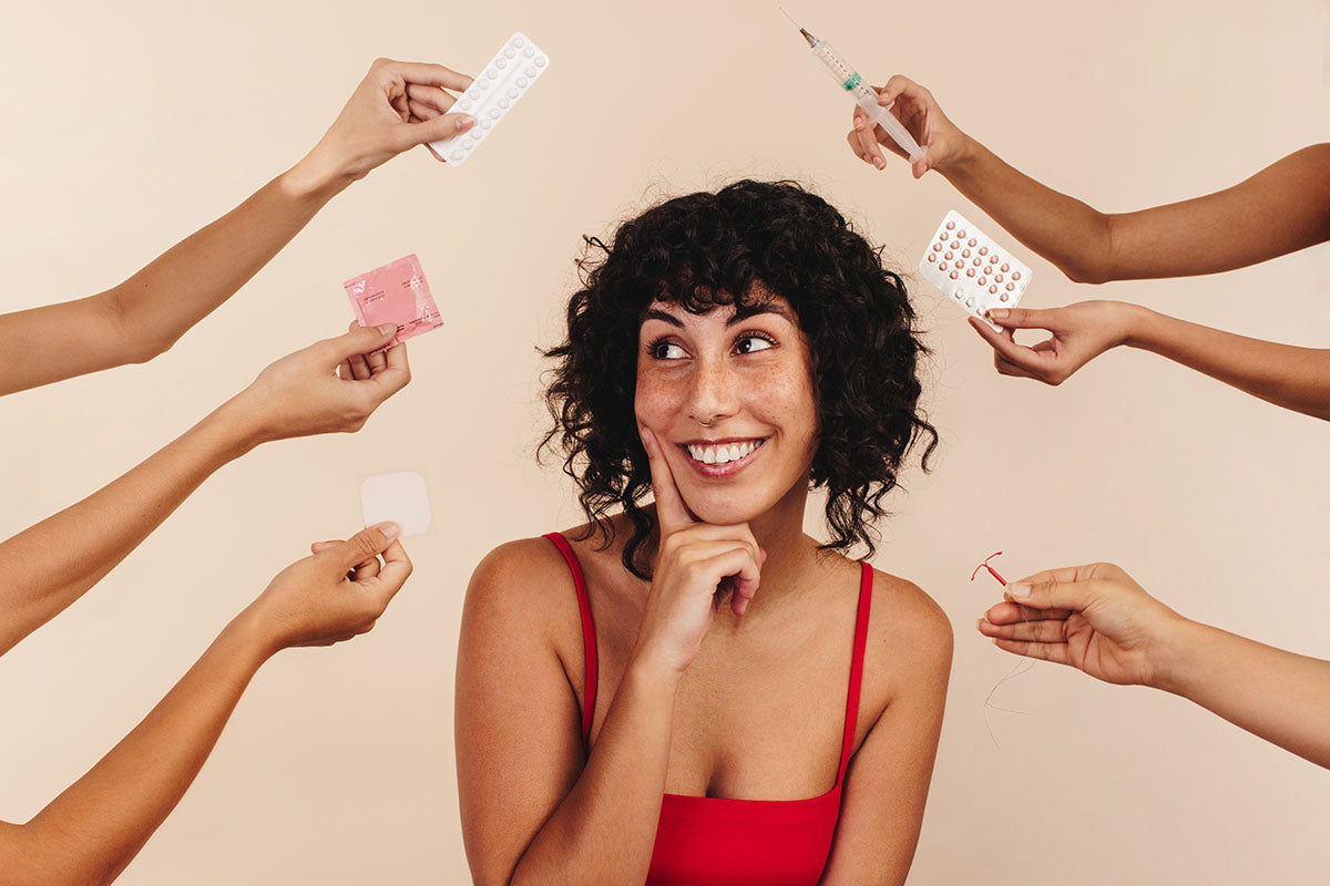 A woman with different types of birth control surrounding her.